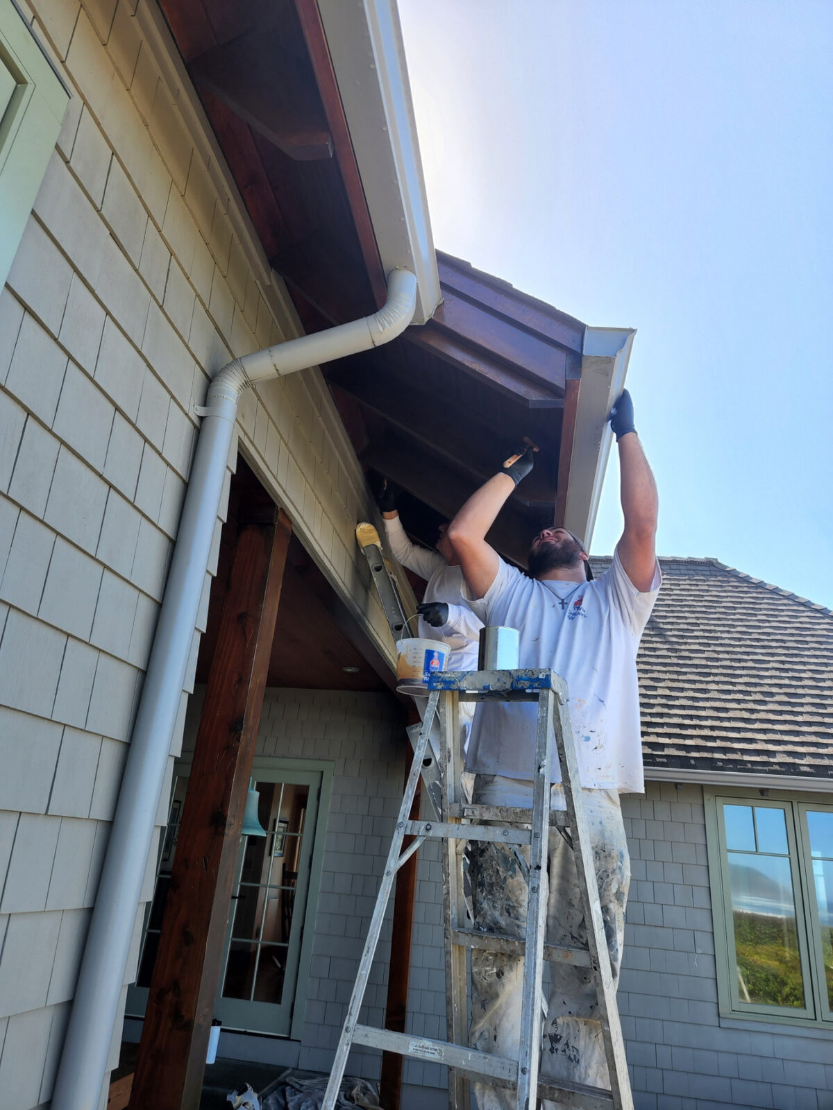 Paint Doctor's Painting uses ladders for soffit work.