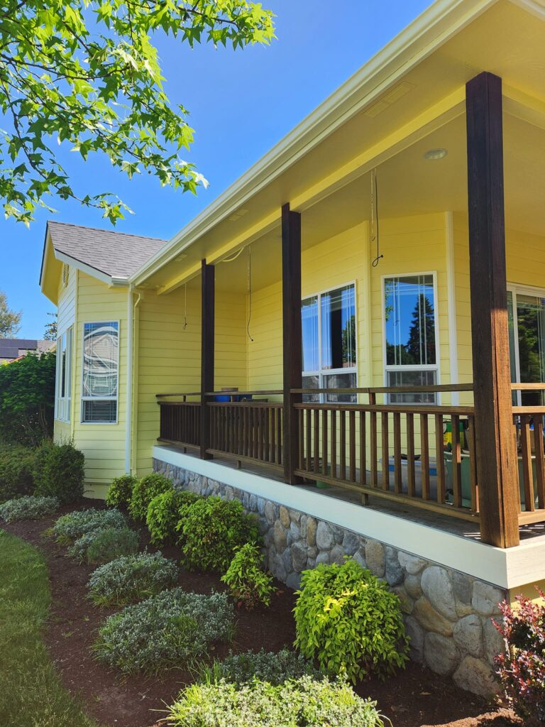 This freshly painted yellow house looks great with white trim and dark wood porch railing.
