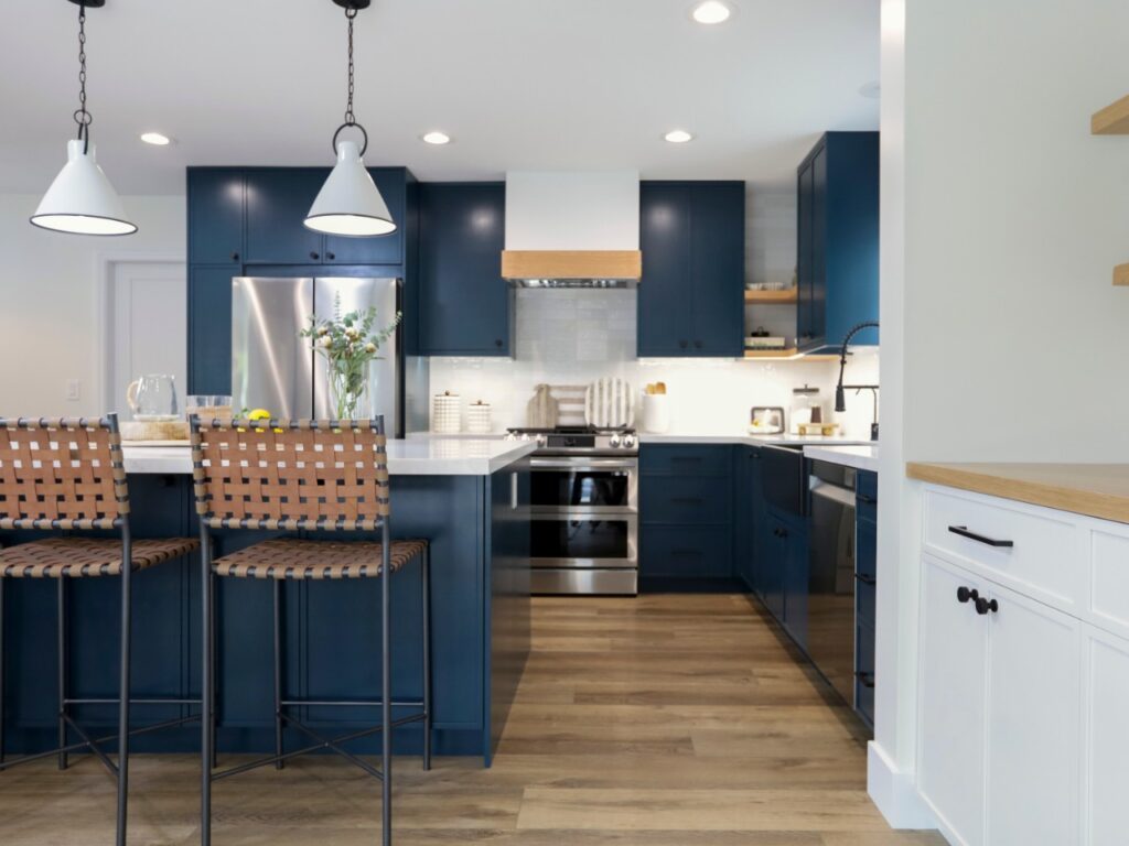 Black appliances and black hardware add drama to the dark blue cabinets.